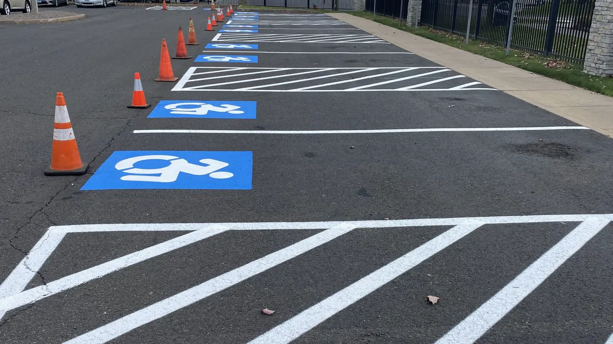 Freshly painted accessible parking stalls with blue symbols and white cross-hatched access aisles